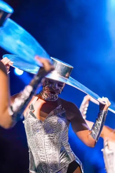 Performer in a futuristic silver costume with a circular metallic headpiece during the live dinner show at Nouba, Marrakech