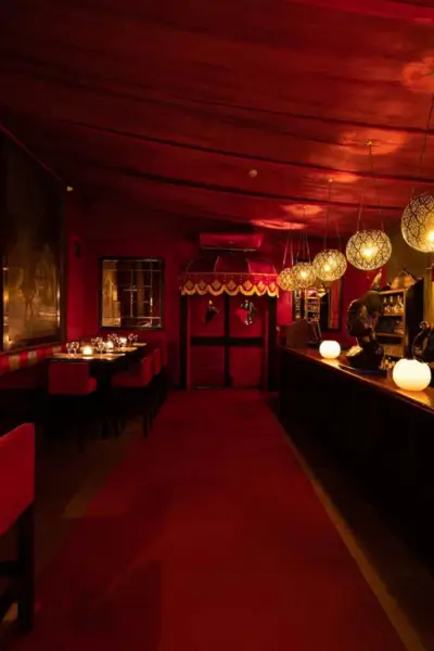 Opulent red dining lounge with high bar seating and lanterns at Palais Jad Mahal, Marrakech